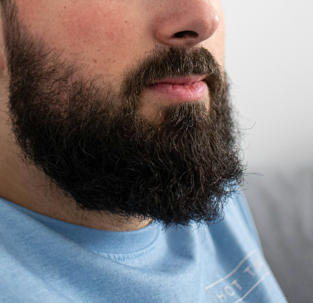 Professional headshot of male tech lead in his 30s with short beard wearing casual navy shirt