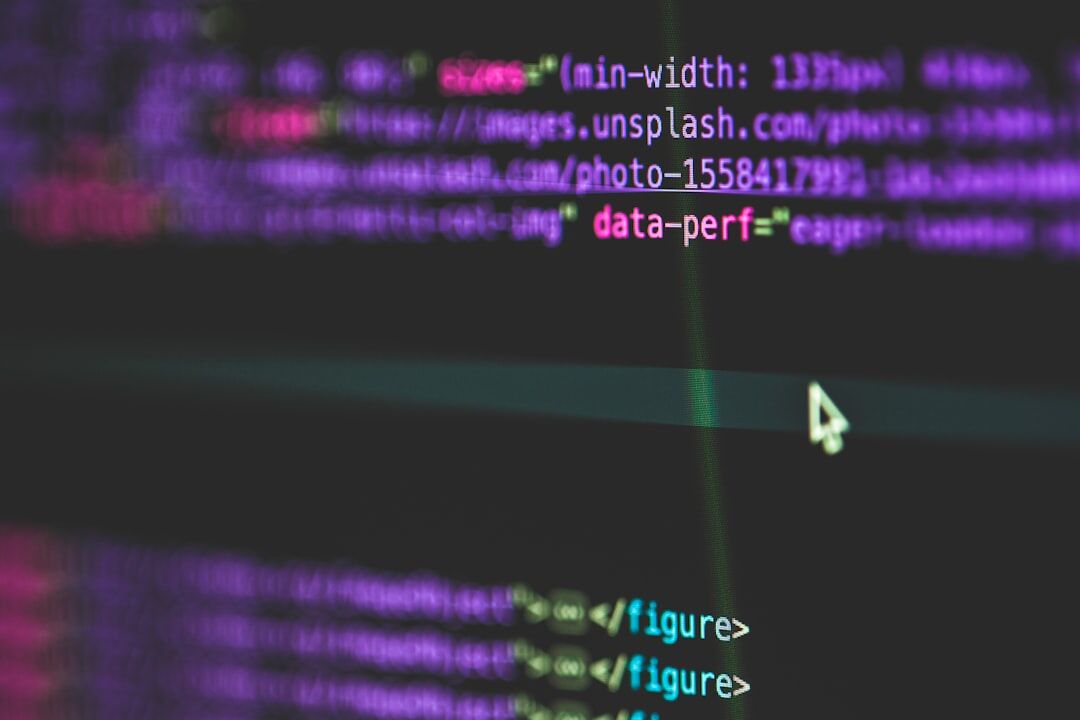 Software developer coding on monitor with programming code visible on screen